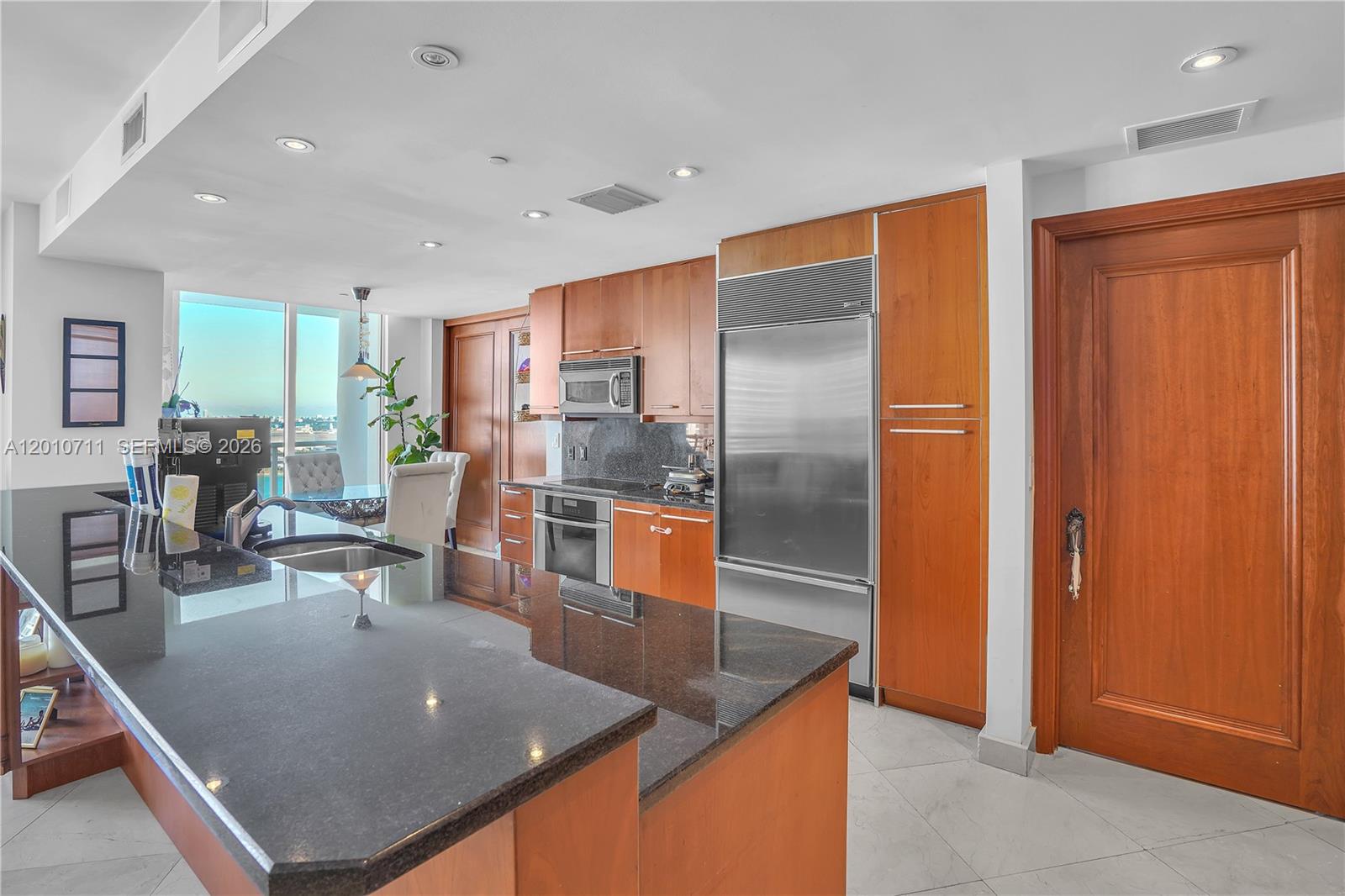 901 Brickell Key Boulevard, Unit 2807 Miami, FL 33131 - Photo 8 of 29 a kitchen with stainless steel appliances granite countertop a refrigerator a stove and a sink