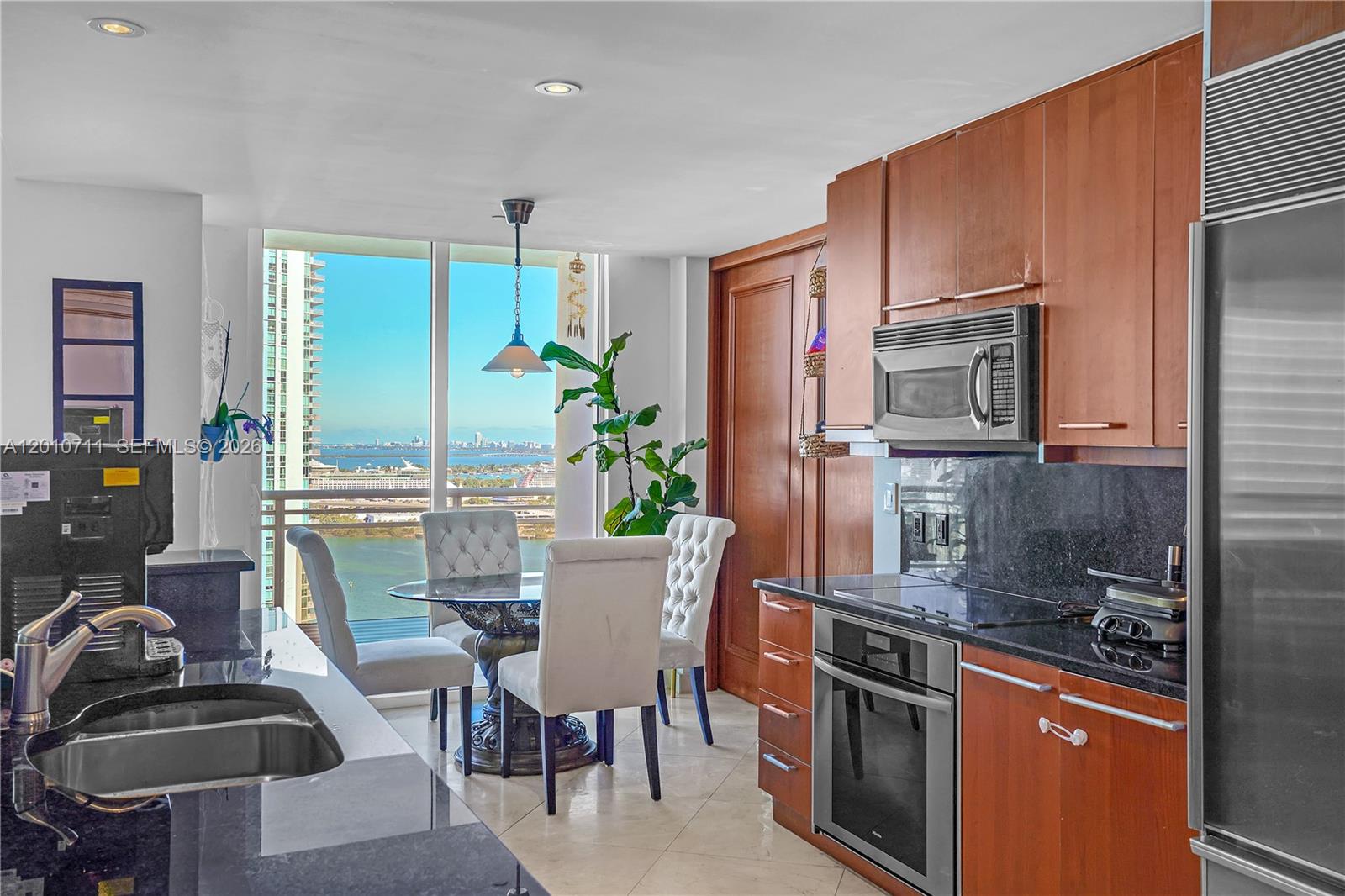 901 Brickell Key Boulevard, Unit 2807 Miami, FL 33131 - Photo 9 of 29 a dining room with furniture a window and kitchen view
