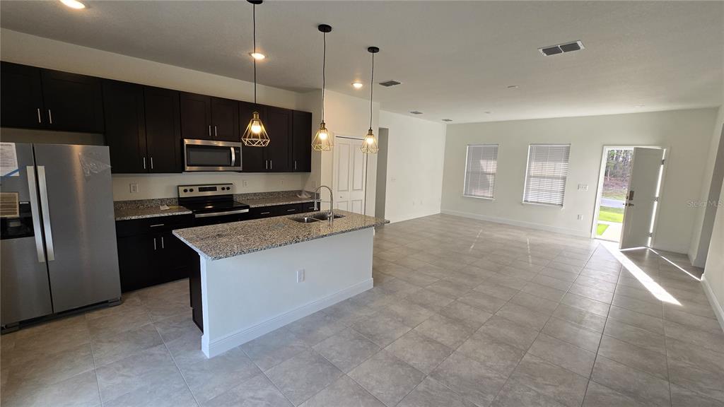 6325 Southwest 144th Lane Road Ocala, FL 34473 - Photo 3 of 31 a kitchen with stainless steel appliances a refrigerator and a stove top oven