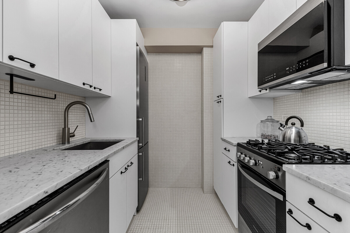 123 East 75th Street, Unit 7D Manhattan, NY 10021 - Photo 5 of 9 a kitchen with stainless steel appliances granite countertop a sink stove and microwave
