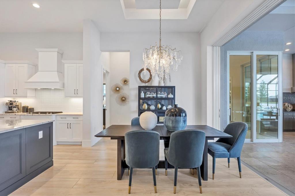 8477 Pavia Way Lakewood Ranch, FL 34202 - Photo 12 of 67 a view of a dining room with furniture and chandelier
