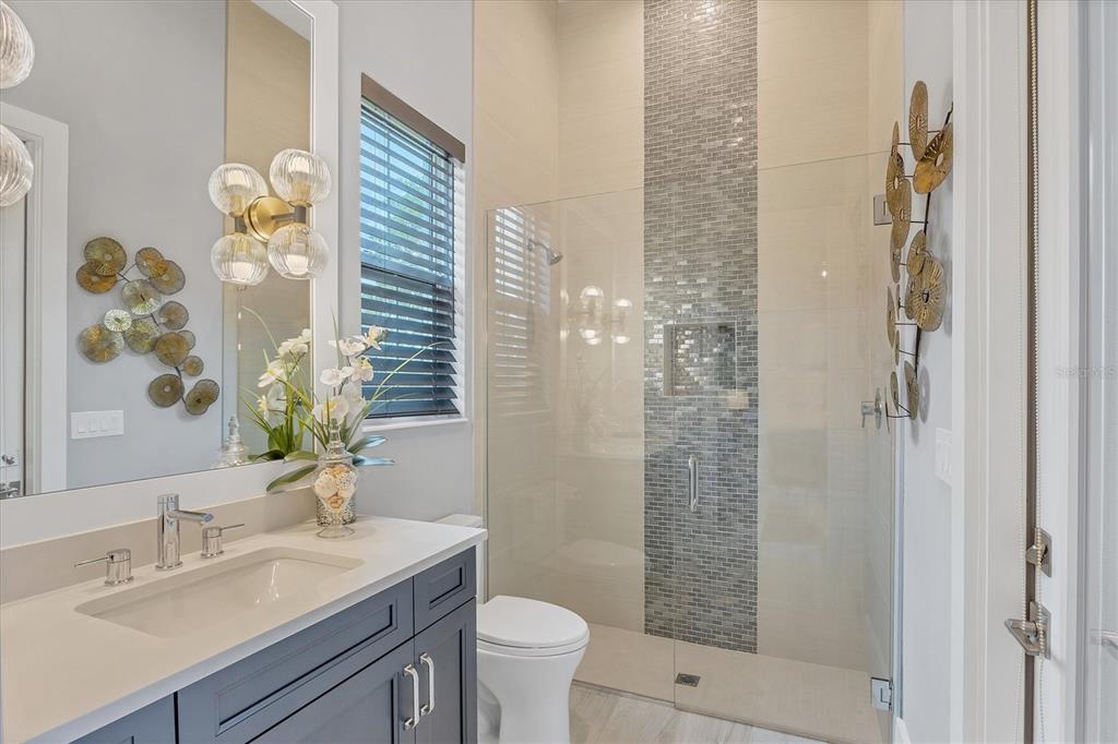 8477 Pavia Way Lakewood Ranch, FL 34202 - Photo 18 of 67 a bathroom with a granite countertop sink a toilet and shower