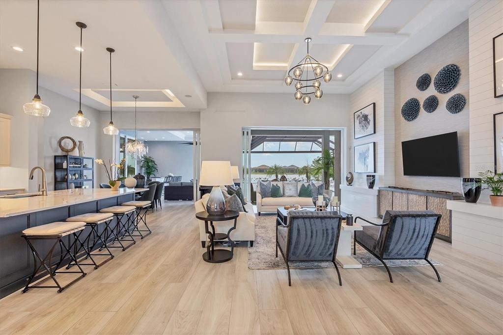 8477 Pavia Way Lakewood Ranch, FL 34202 - Photo 2 of 67 a living room with furniture a flat screen tv and kitchen view