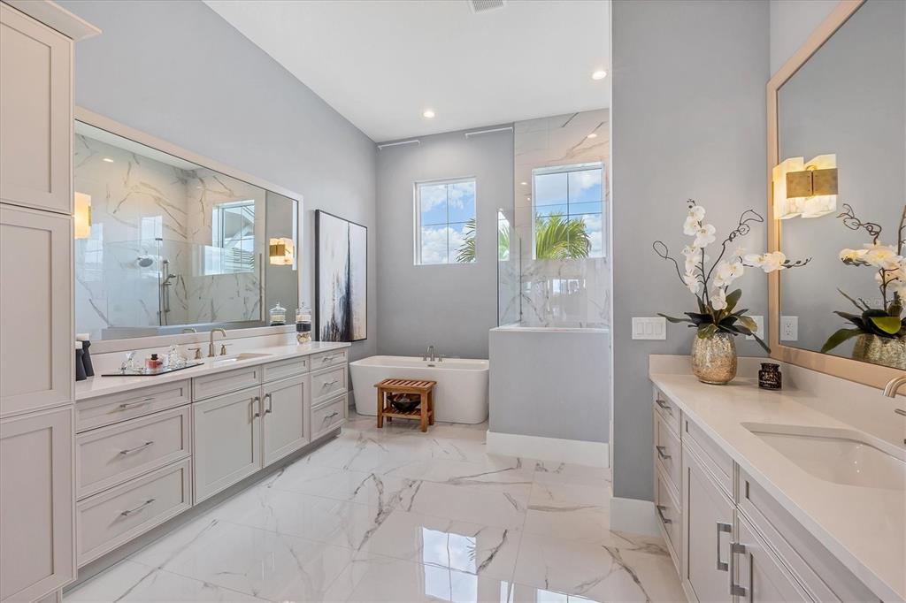 8477 Pavia Way Lakewood Ranch, FL 34202 - Photo 21 of 67 a bathroom with a double vanity sink a large mirror and a bathtub