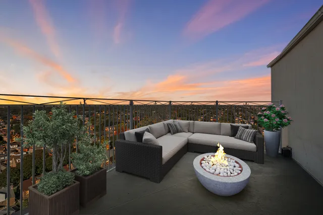 a view of a patio with couches potted plants and ocean view