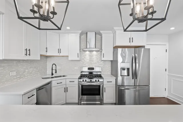 a kitchen with stainless steel appliances a stove a sink and cabinets