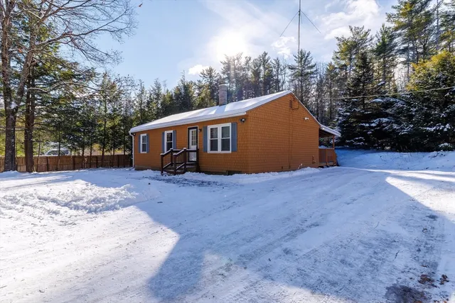 a view of a house with backyard and trees