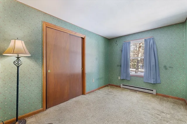 an empty room with window and closet area