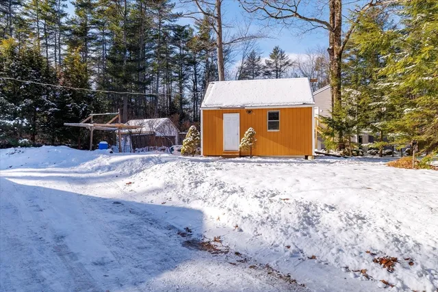 a front view of a house with a yard covered with snow in front of house