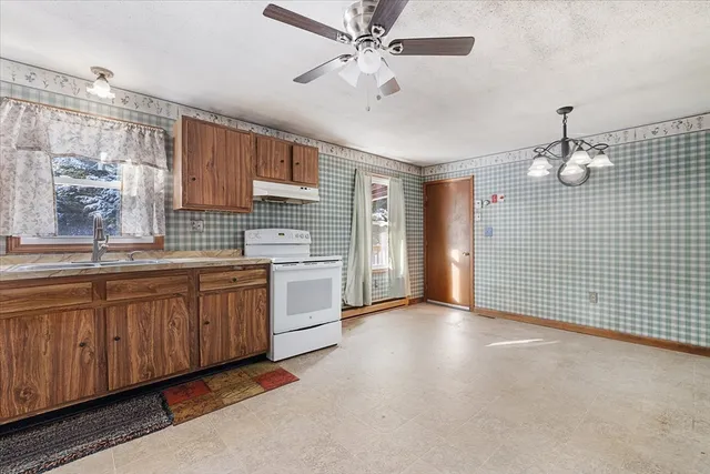 a open kitchen with sink cabinets and chandelier