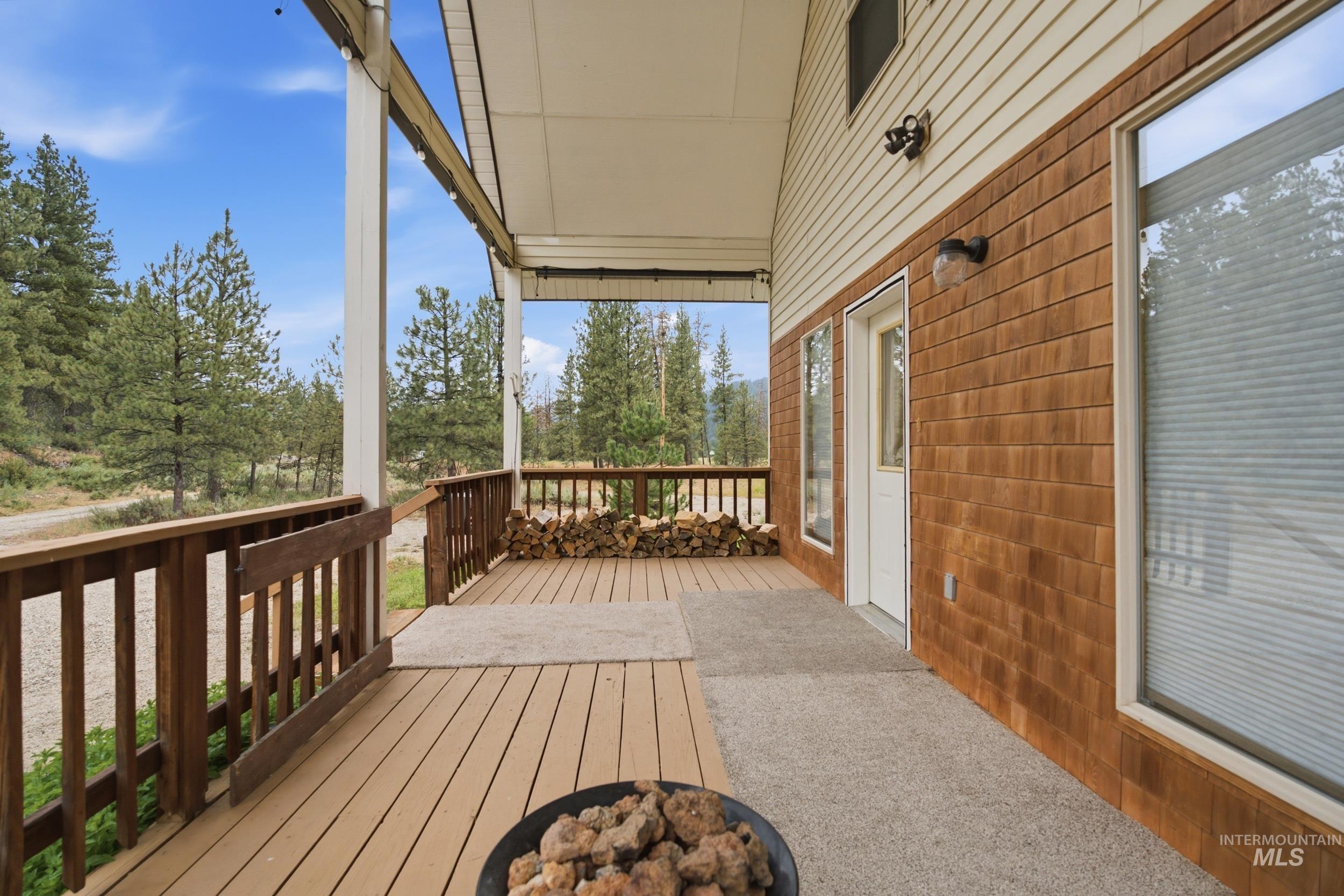 3980 North Pine-Featherville Road Mountain Home, ID 83647 - Photo 34 of 35 Covered front porch with wood-finish decking and dark wood railings