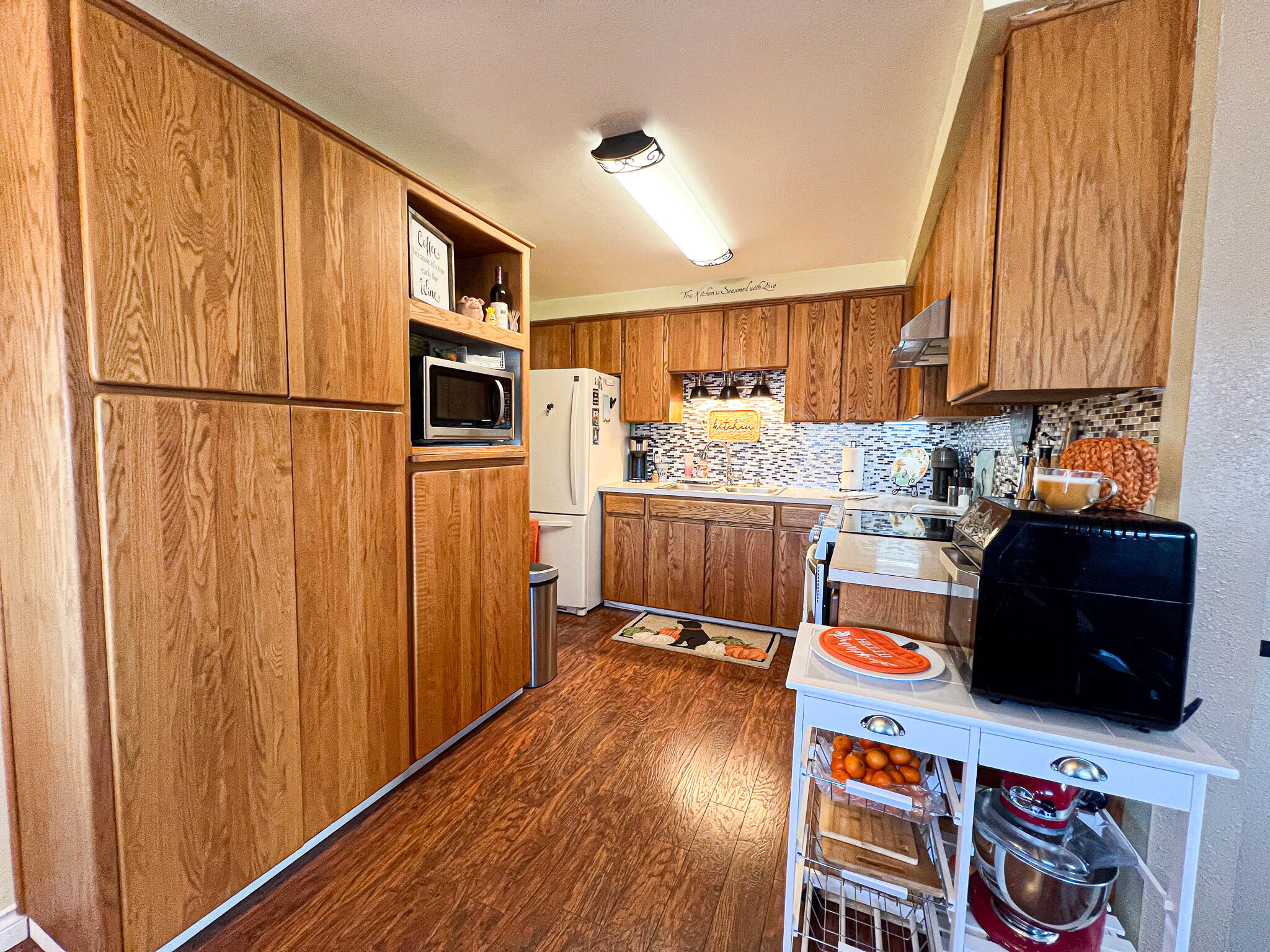 1225 East B Street Fossil, OR 97830 - Photo 9 of 33 a kitchen with stainless steel appliances granite countertop a refrigerator a stove a sink dishwasher and wooden cabinets with wooden floor