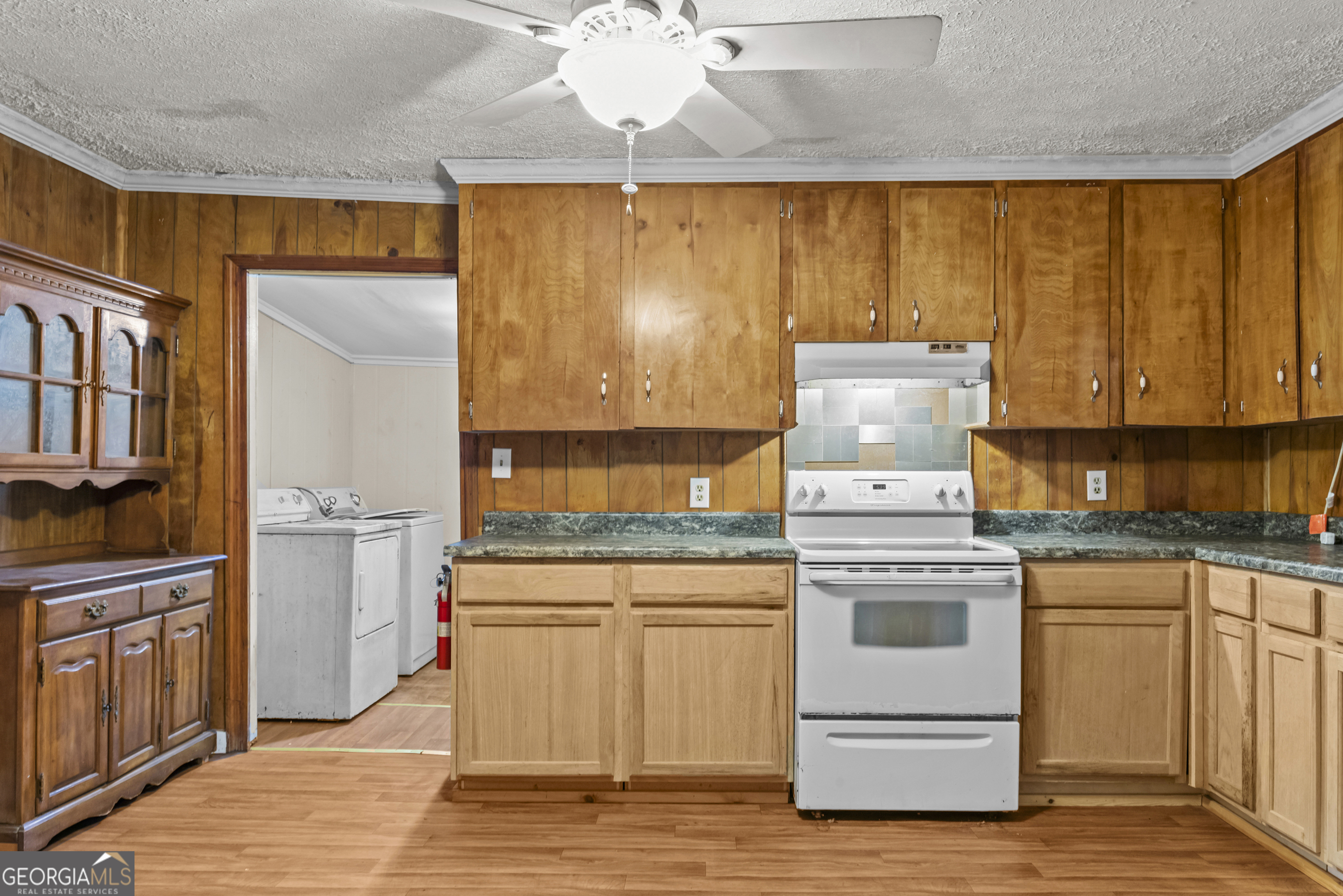 546 South 4th Street Madison, GA 30650 - Photo 12 of 22 a kitchen with a stove a sink and white cabinets