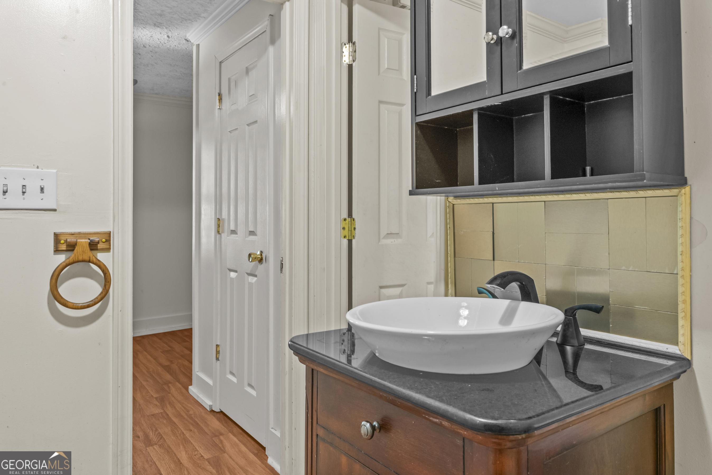 546 South 4th Street Madison, GA 30650 - Photo 17 of 22 a bathroom with a granite countertop sink and a mirror