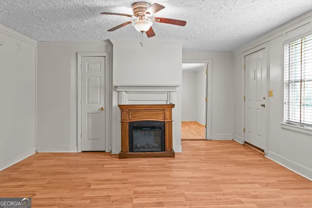 wooden floor fireplace and window in an empty room