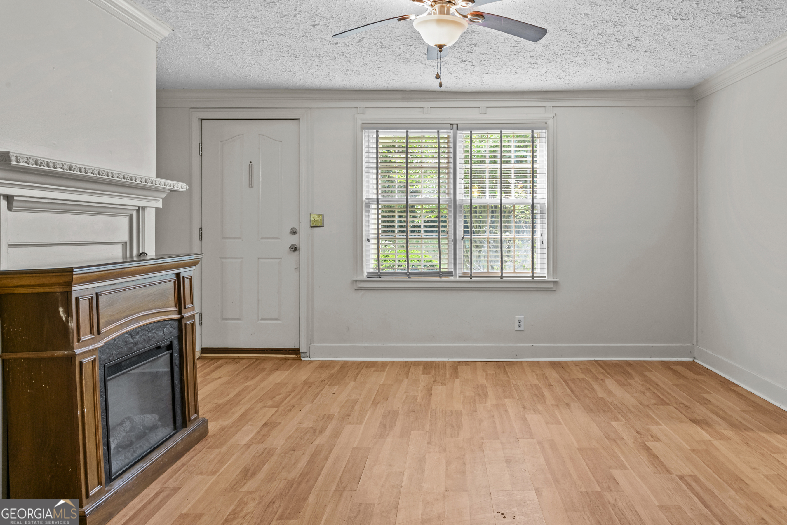 546 South 4th Street Madison, GA 30650 - Photo 9 of 22 an empty room with wooden floor fan and windows