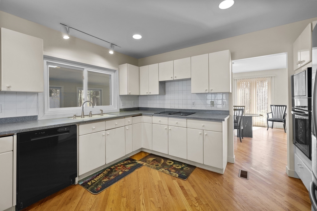 70 Cutters Ridge Road Carlisle, MA 01741 - Photo 6 of 36 a kitchen with granite countertop a stove a sink and white cabinets