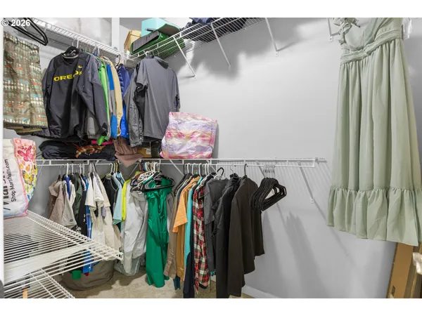 a view of walk in closet with clothes and shoes