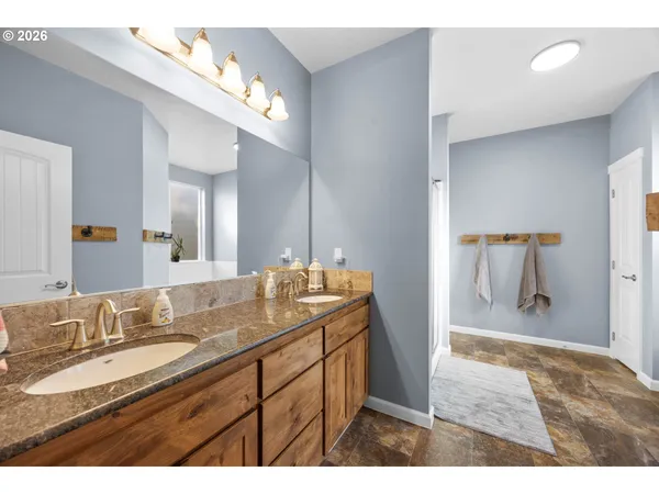a bathroom with a granite countertop sink a mirror and a shower
