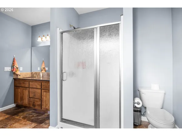 a bathroom with a granite countertop sink toilet and shower