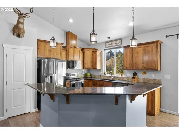 a kitchen with kitchen island granite countertop a sink cabinets and window