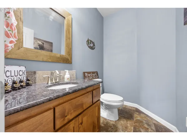 a bathroom with a granite countertop sink a toilet and a mirror