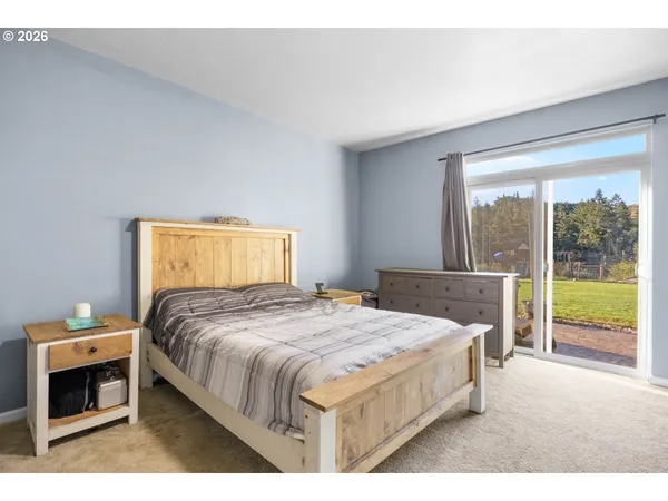 a bedroom with a bed and a dresser next to a window