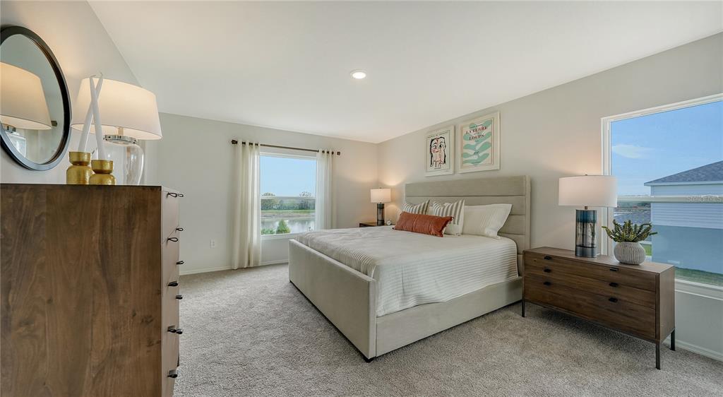 13113 Bayberry Way Parrish, FL 34219 - Photo 9 of 20 a bedroom with a bed a mirror on dresser and a chandelier