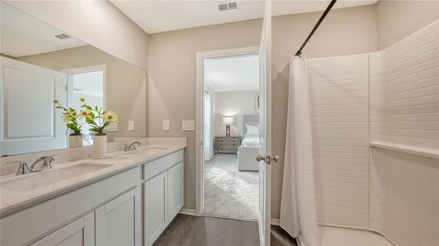 a en suite bathroom with a granite countertop sink and a mirror