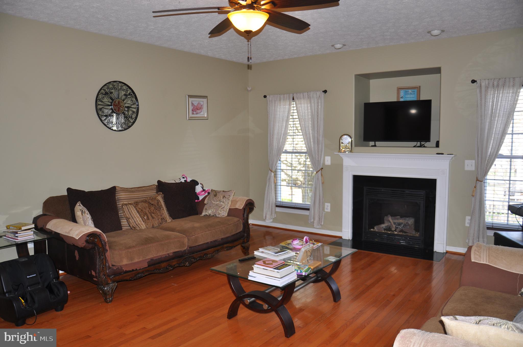 10621 Gallant Fox Way Ruther Glen, VA 22546 - Photo 18 of 65 a living room with furniture a flat screen tv and a fireplace