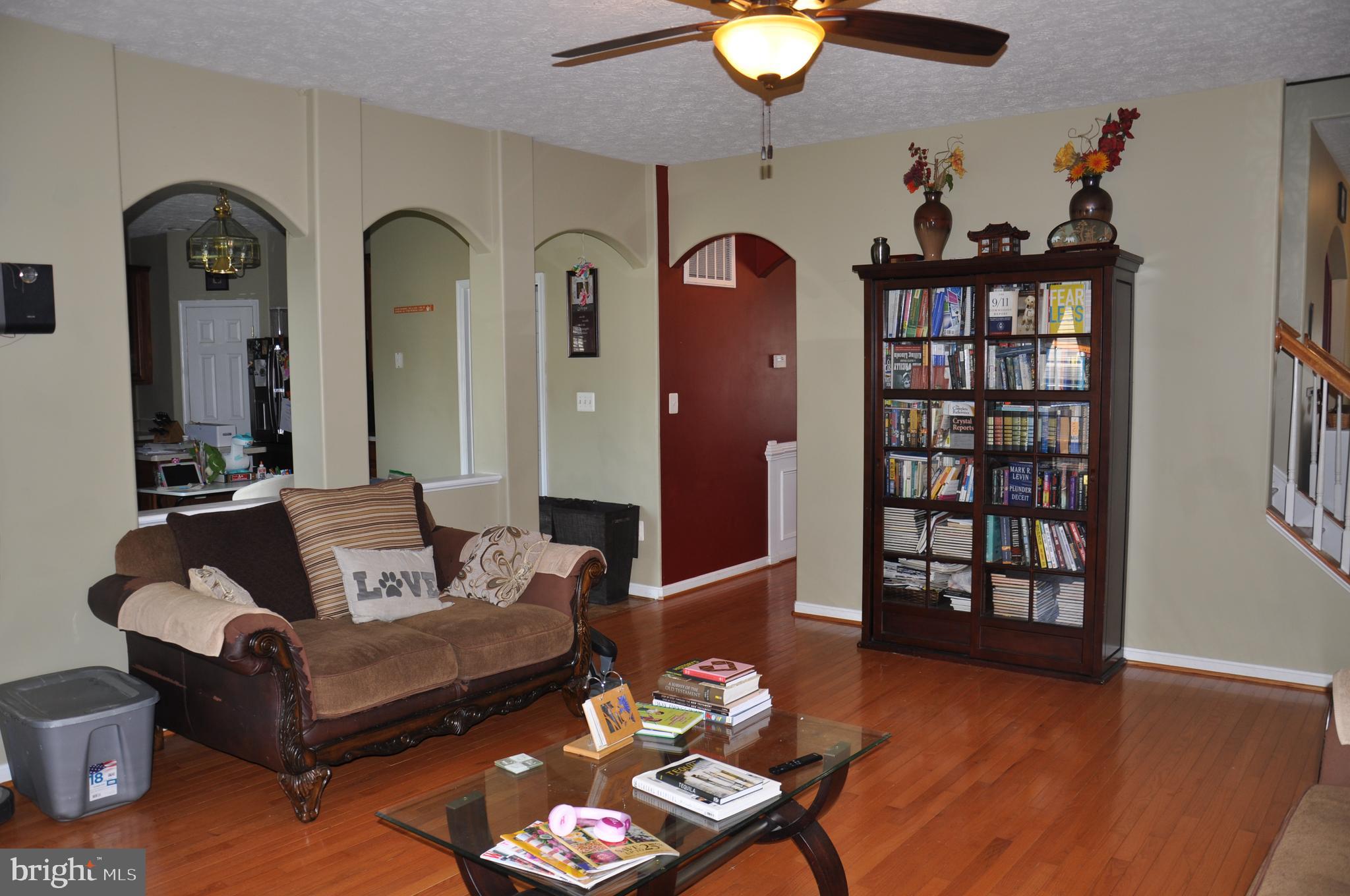10621 Gallant Fox Way Ruther Glen, VA 22546 - Photo 20 of 65 a living room with furniture a dining table and a chandelier