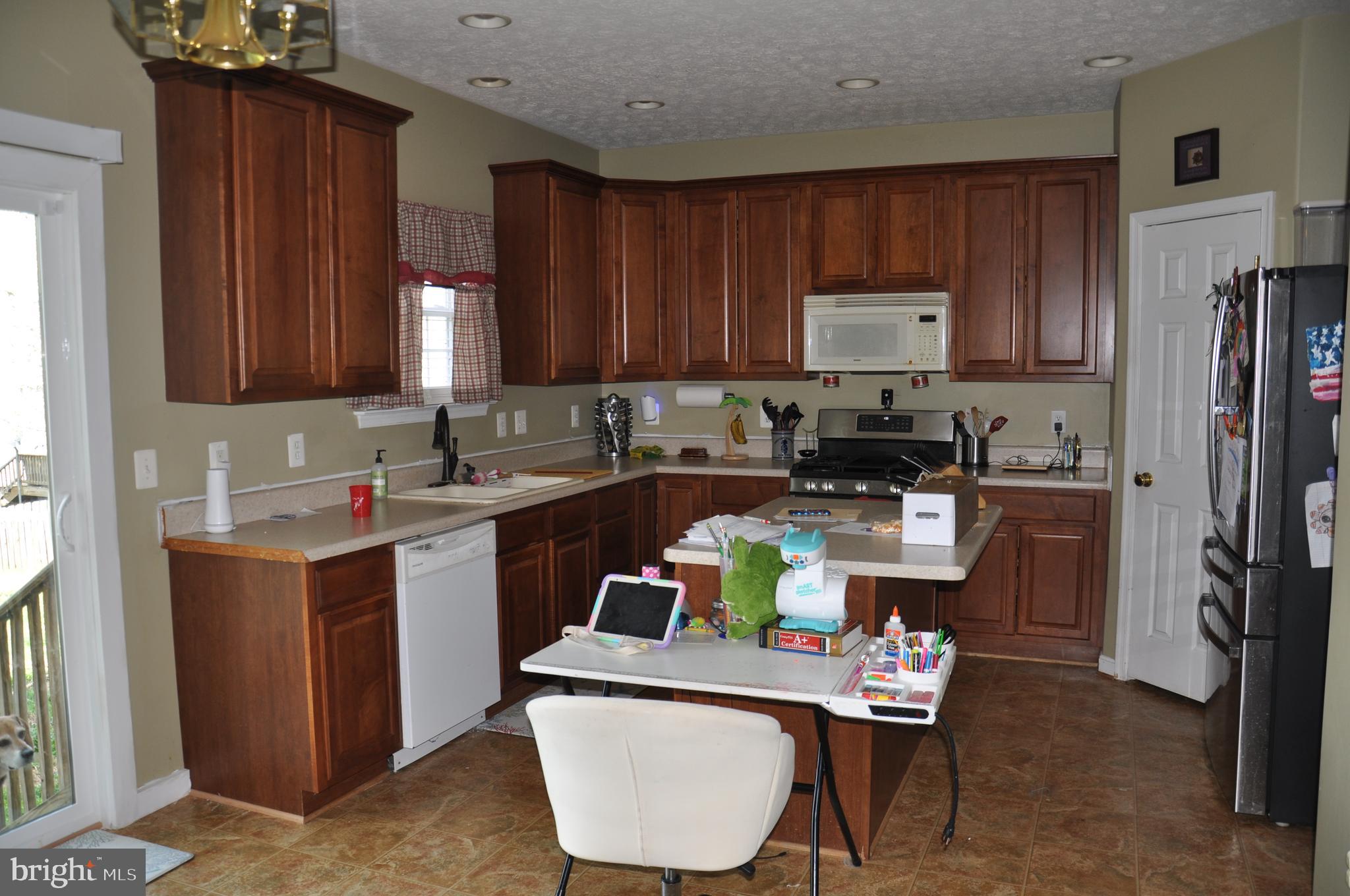 10621 Gallant Fox Way Ruther Glen, VA 22546 - Photo 21 of 65 a kitchen with a refrigerator sink and white cabinets