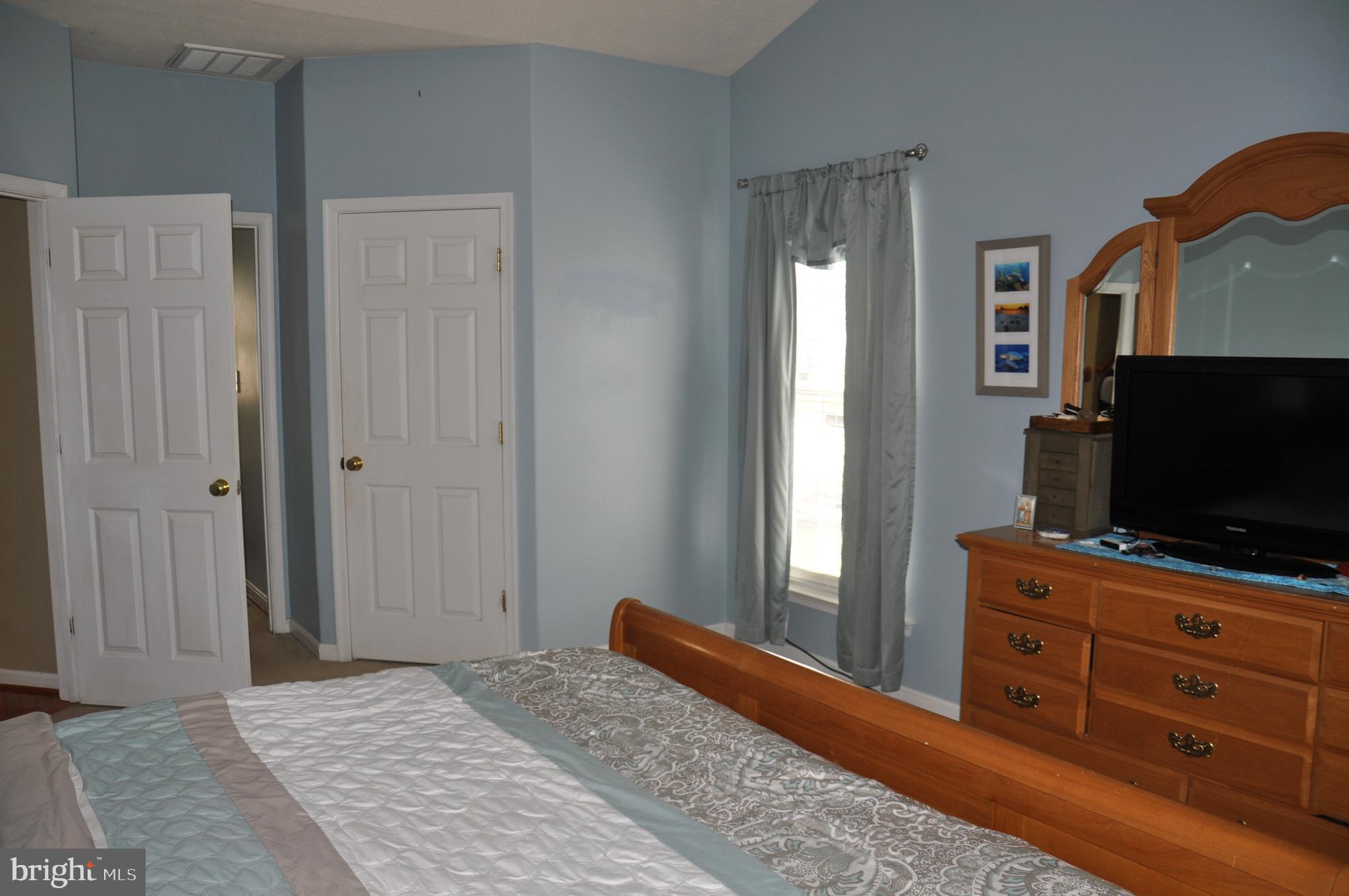 10621 Gallant Fox Way Ruther Glen, VA 22546 - Photo 28 of 65 a bedroom with window and flat screen tv