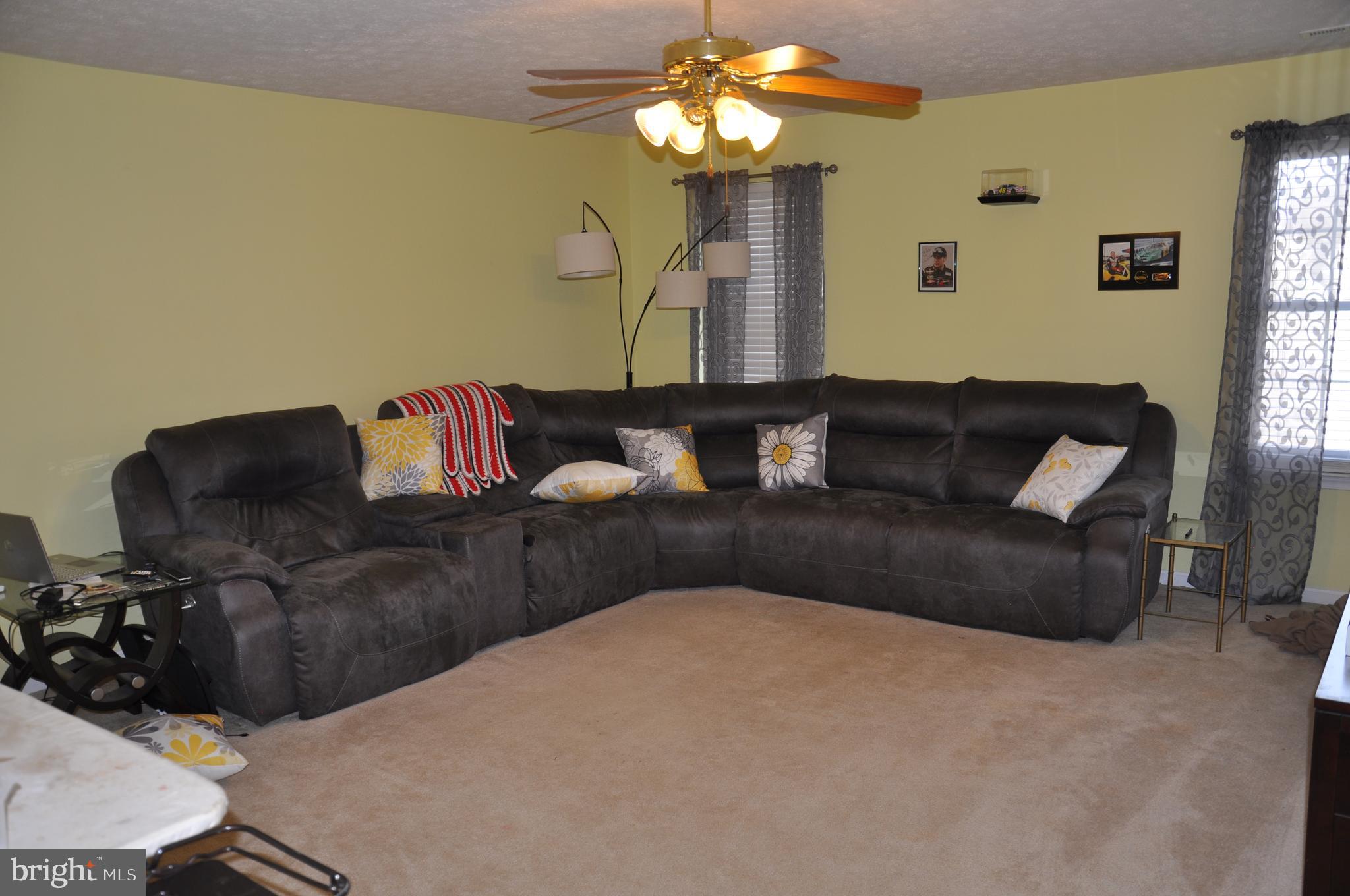 10621 Gallant Fox Way Ruther Glen, VA 22546 - Photo 51 of 65 a living room with furniture and a chandelier