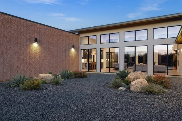 a living room with furniture a large window and stainless steel appliances