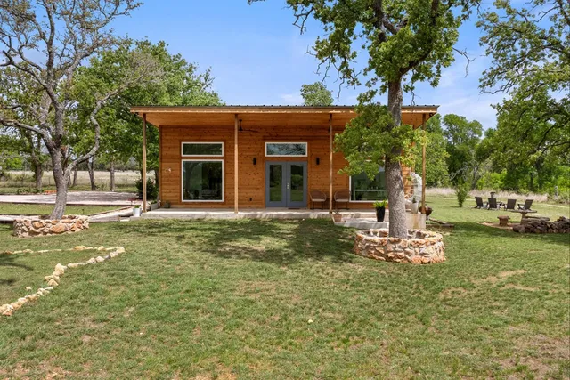 a view of a house with backyard and sitting area