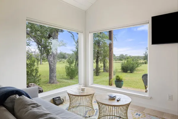a living room with furniture kitchen view and a chandelier