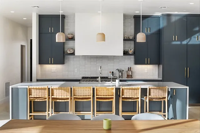 a large kitchen with stainless steel appliances granite countertop a large island a stove and a sink