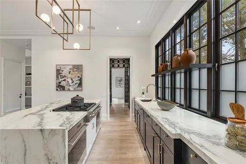 a kitchen with stainless steel appliances granite countertop a kitchen island a stove a sink and a refrigerator