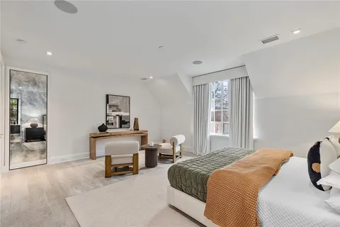 a bedroom with a bed and large windows