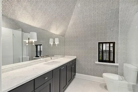 a bathroom with a double vanity sink a toilet and a mirror