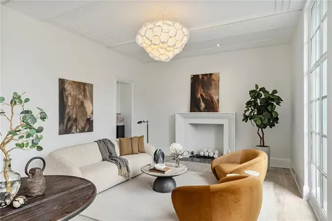 a living room with furniture a chandelier and a window