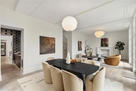 a dining room with wooden floor a chandelier a wooden table and chairs