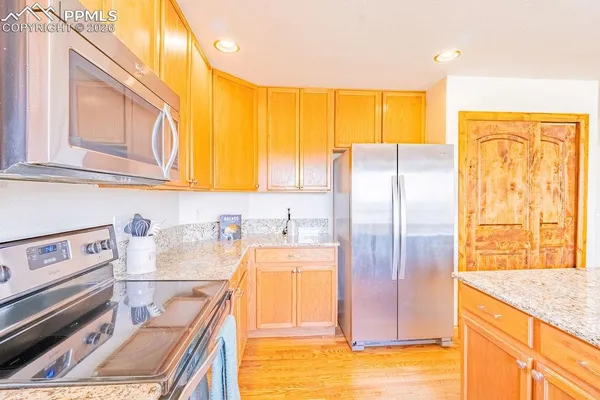 a kitchen with stainless steel appliances granite countertop a refrigerator and a stove