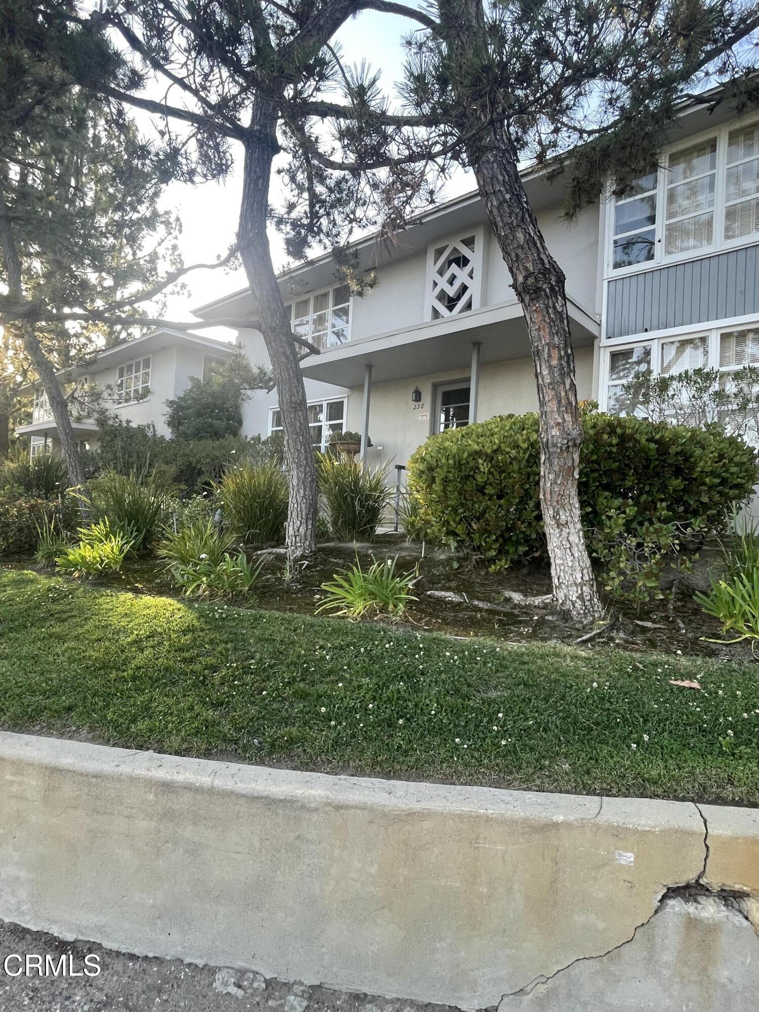a front view of a house with a yard and potted plants