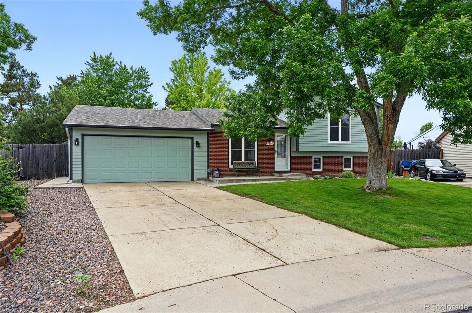 a front view of a house with a garden and trees