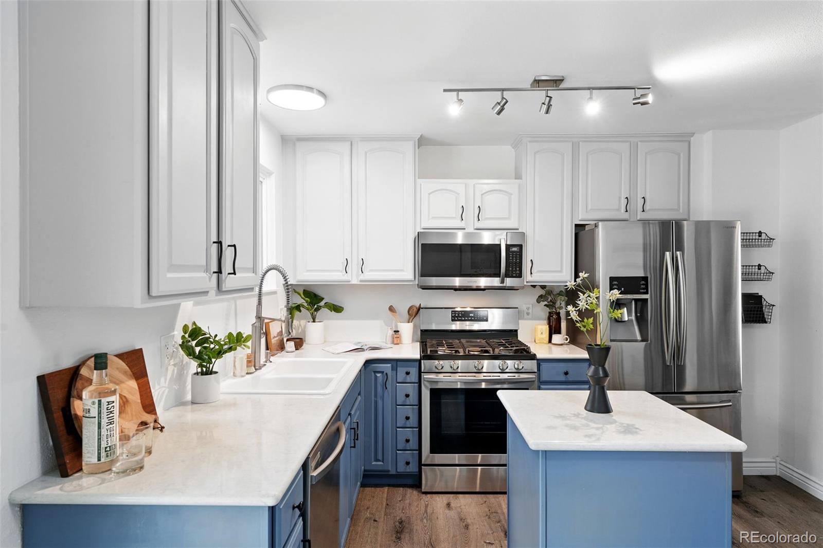 9315 Field Lane Westminster, CO 80021 - Photo 11 of 50 a kitchen with stainless steel appliances a stove a sink a refrigerator a center island and a refrigerator