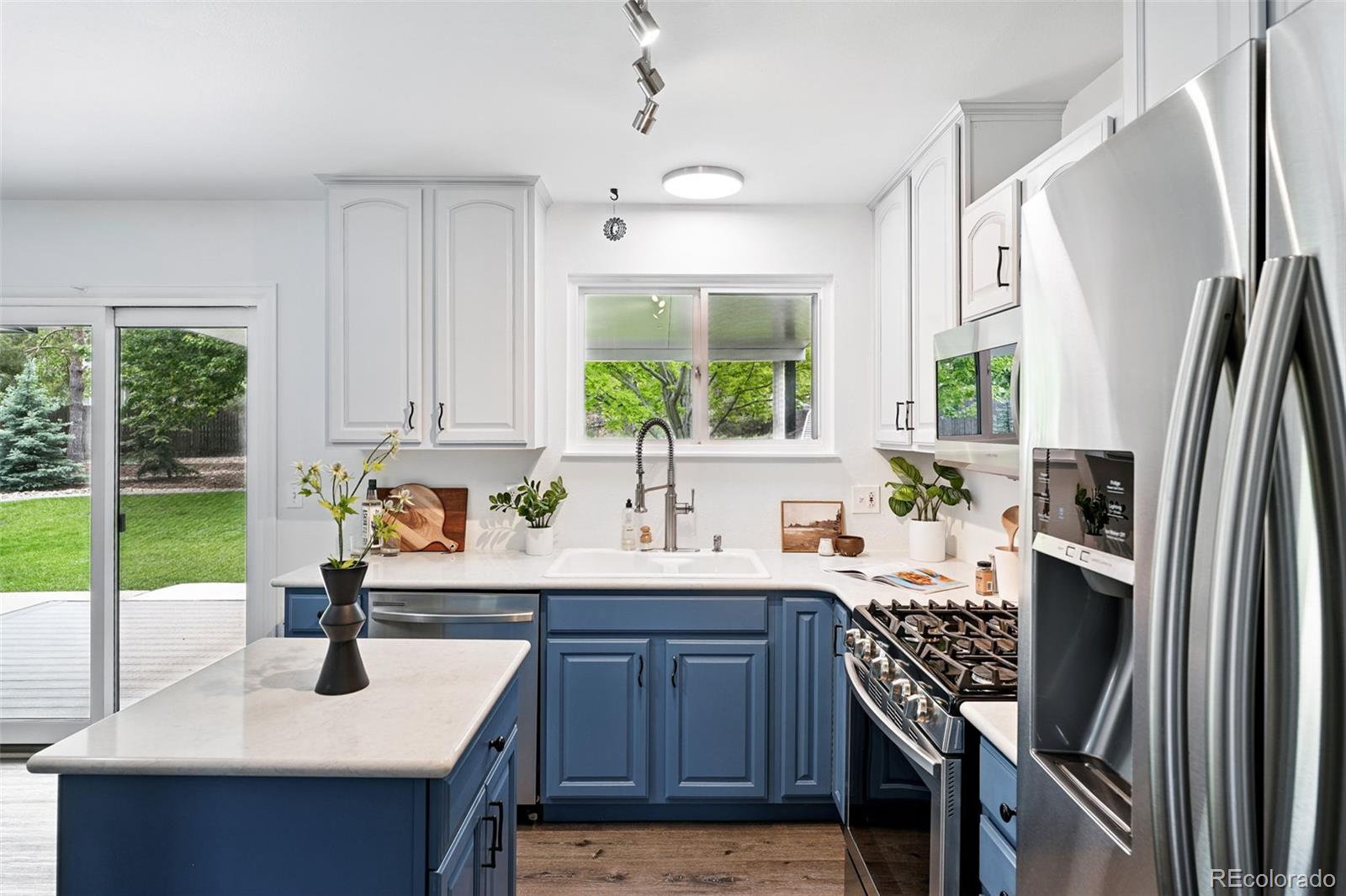 9315 Field Lane Westminster, CO 80021 - Photo 12 of 50 a kitchen with kitchen island granite countertop a sink appliances cabinets and a counter top space