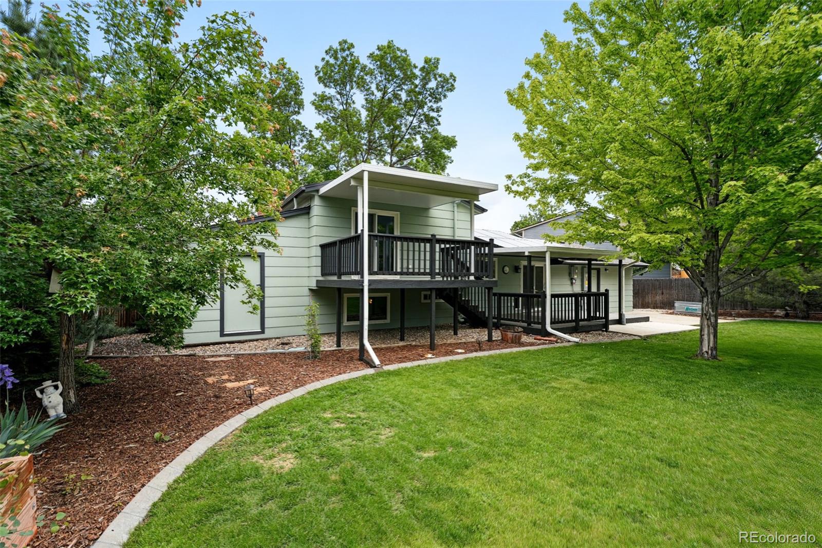 9315 Field Lane Westminster, CO 80021 - Photo 32 of 50 a view of a backyard with table and chairs and a large tree