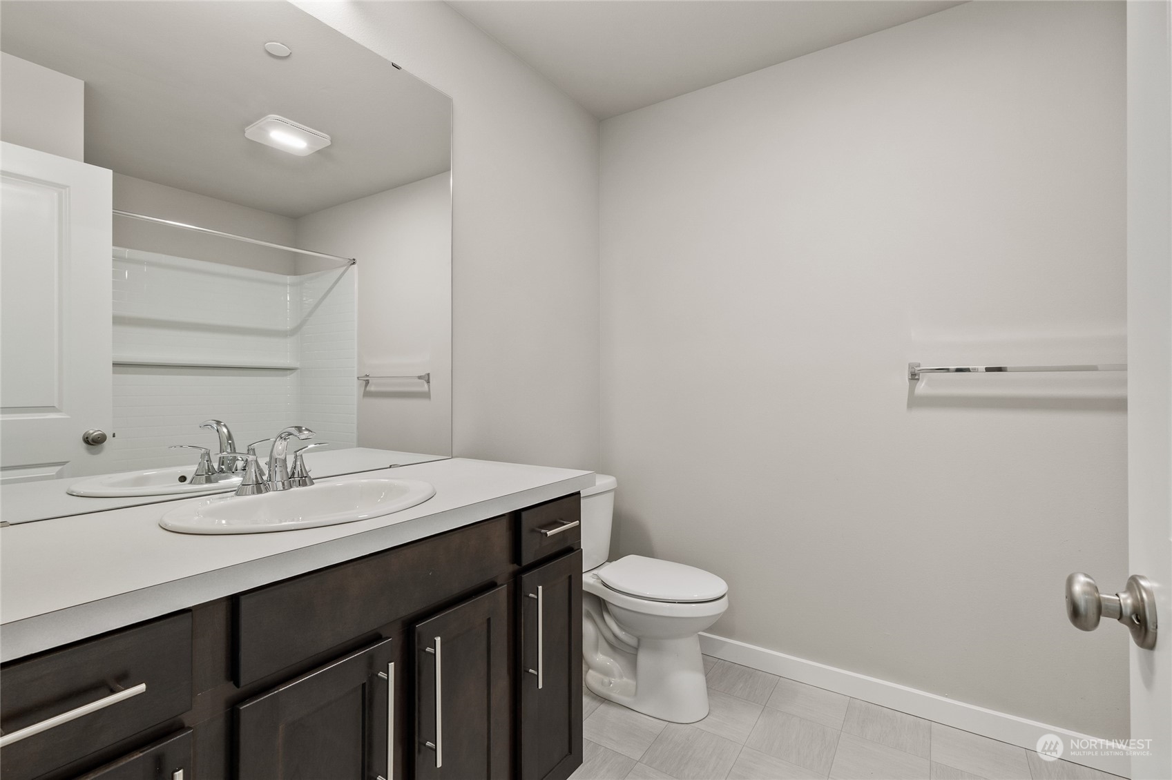 23413 Edmonds Way, Unit E1 Edmonds, WA 98026 - Photo 23 of 27 a bathroom with a granite countertop sink a toilet and a mirror